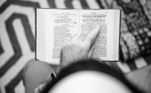 Jewish male wearing Kippah reading praying book